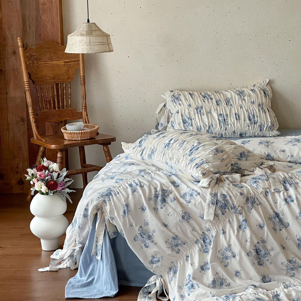 Blue floral cotton muslin bedding set styled in a relaxed French cottage bedroom