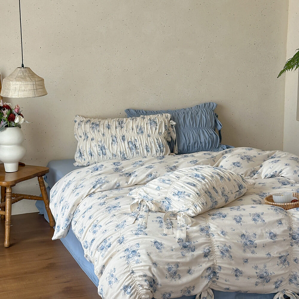 Soft blue floral cotton muslin bedding with layered ruching and ribbon ties