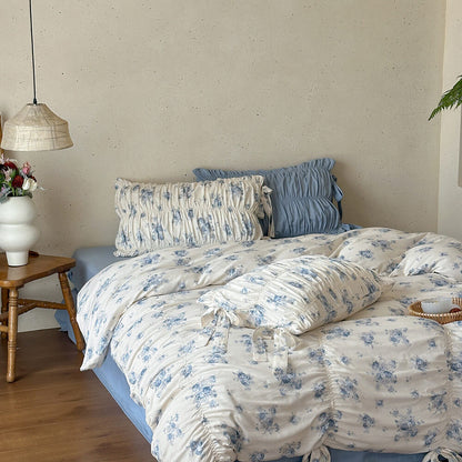 Soft blue floral cotton muslin bedding with layered ruching and ribbon ties