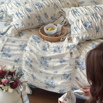 Ruched blue floral bedding set with gathered pillow shams and cottage-style texture