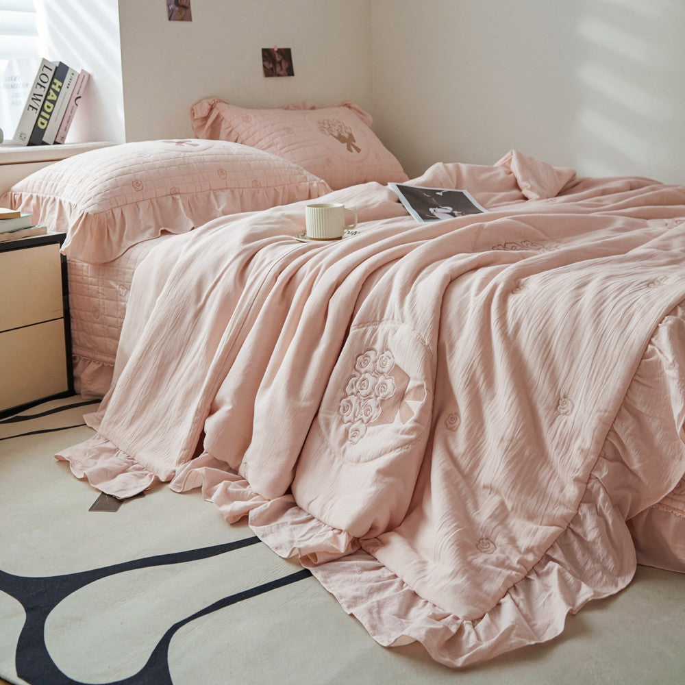 A full bed featuring the pink rose quilted bedding set in a bright French embroidered style bedroom.