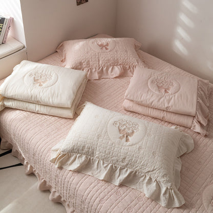 Comparison shot of the pink and cream color options for the French embroidered rose quilted bedding collection.