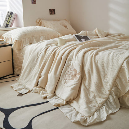 A full bed featuring the cream rose quilted bedding set with French embroidered style bow details in a neutral bedroom.