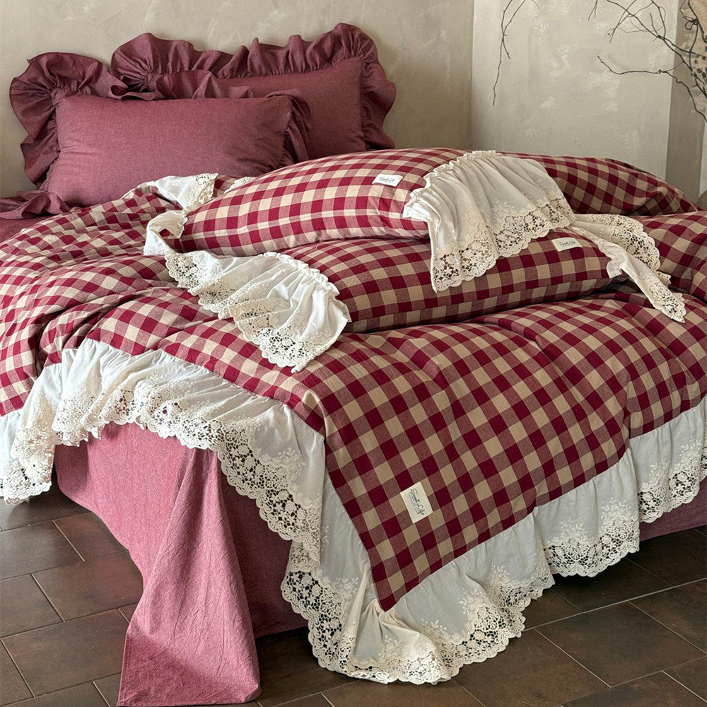 Red and white checkered bedspread with lace trim on a bed.