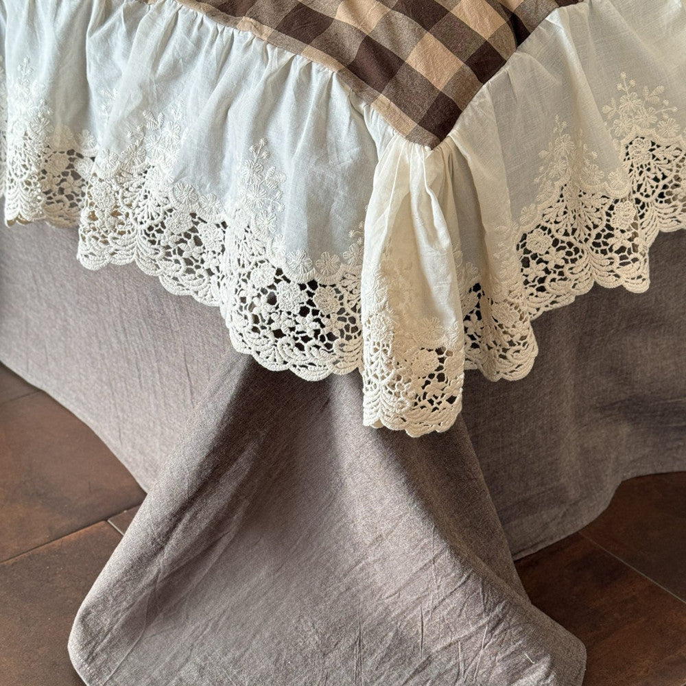 Close-up of a lace-trimmed tablecloth on a wooden surface