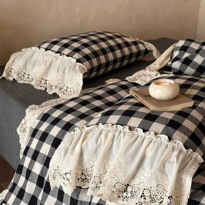 Black and white checkered bedspread with lace trim on a bed.