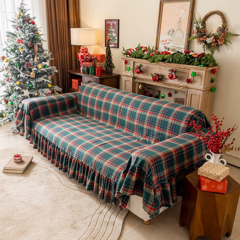 Green tartan plaid Christmas sofa cover with ruffles in a festive living room setting