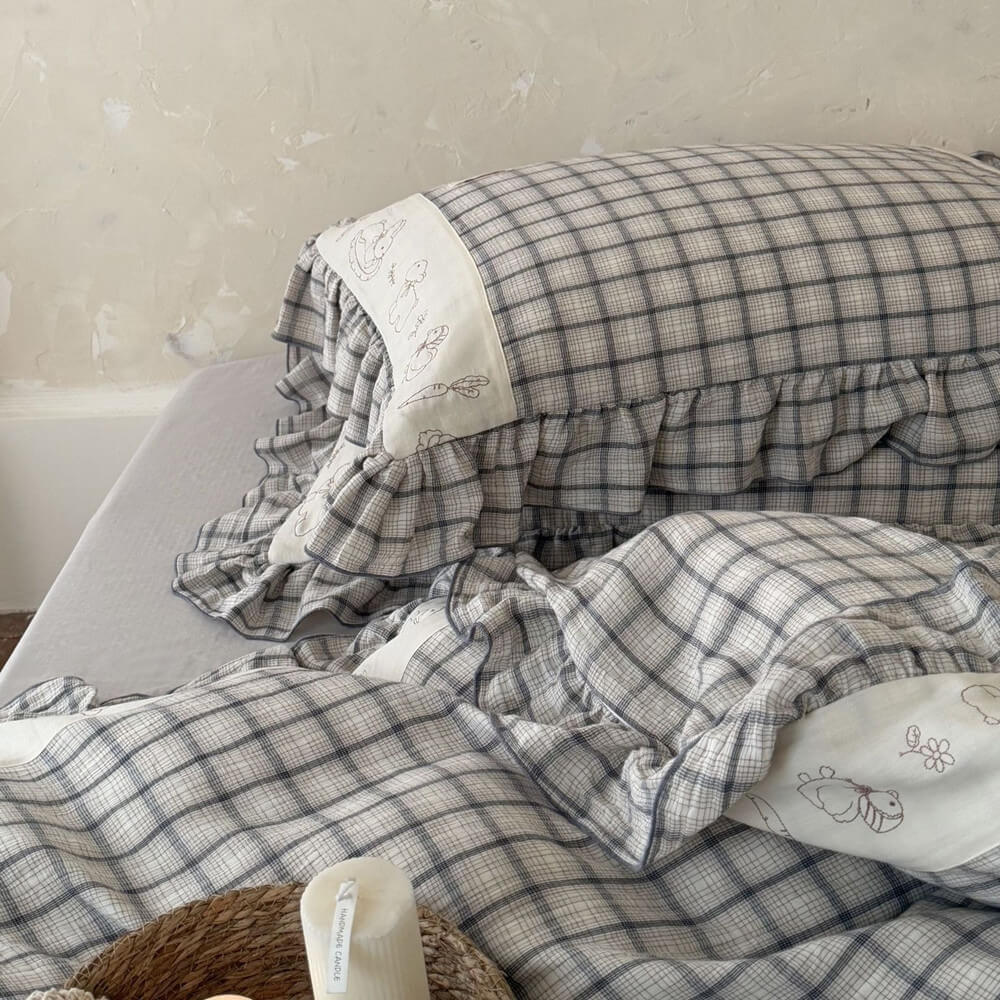 Grey plaid cotton muslin bedding set with ruffled trim on a bed, StuffedHome