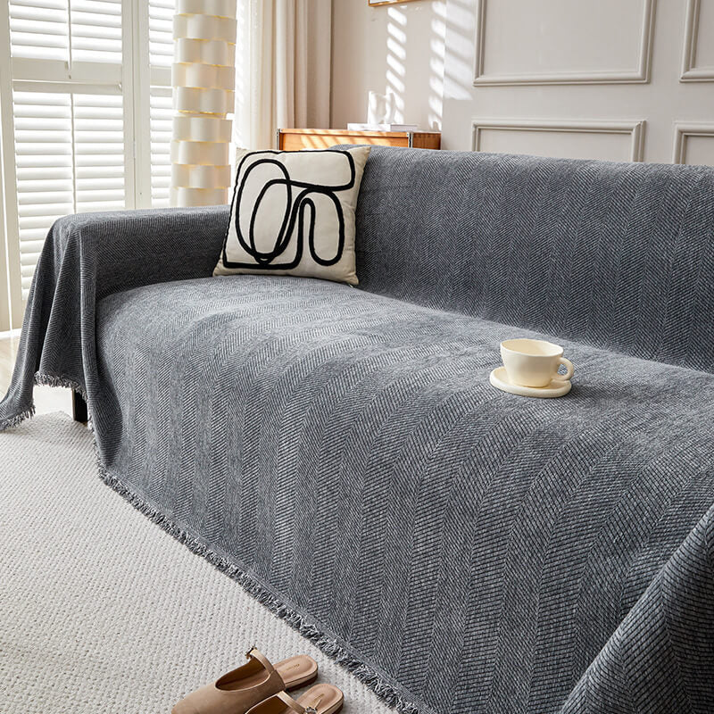 Gray herringbone chenille sofa cover in natural light, with abstract pillow and teacup