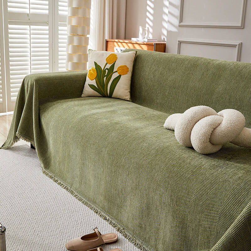 Green herringbone chenille sofa cover with yellow tulip pillow in sunlit living room