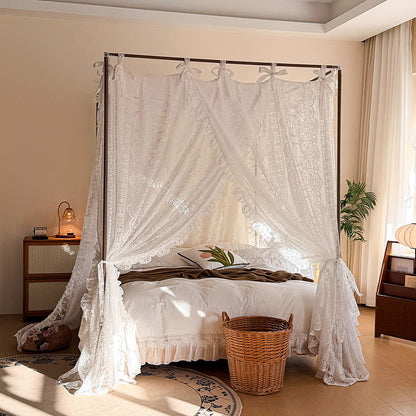 Lace canopy bed curtains on four-poster bed in a cozy, sunlit bedroom with soft bedding.