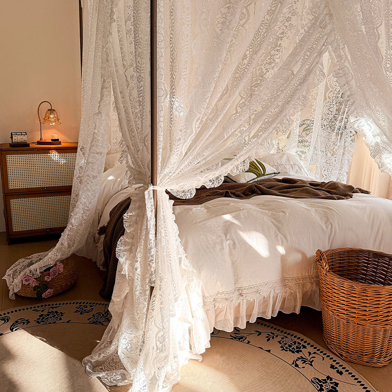 Lace bed canopy curtains on a four-poster bed with soft white bedding in a cozy bedroom