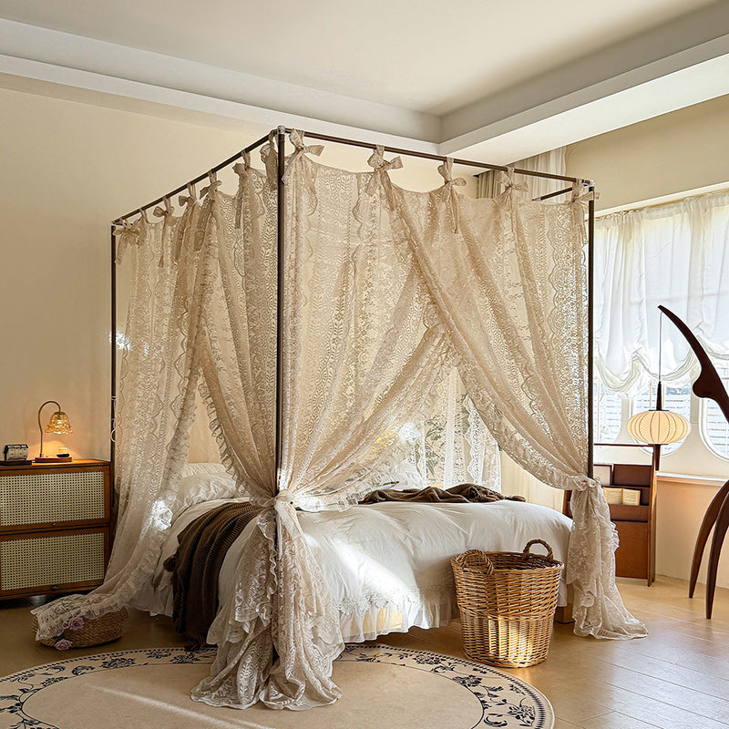 Elegant lace canopy curtains on a four-poster bed in a cozy, sunlit bedroom