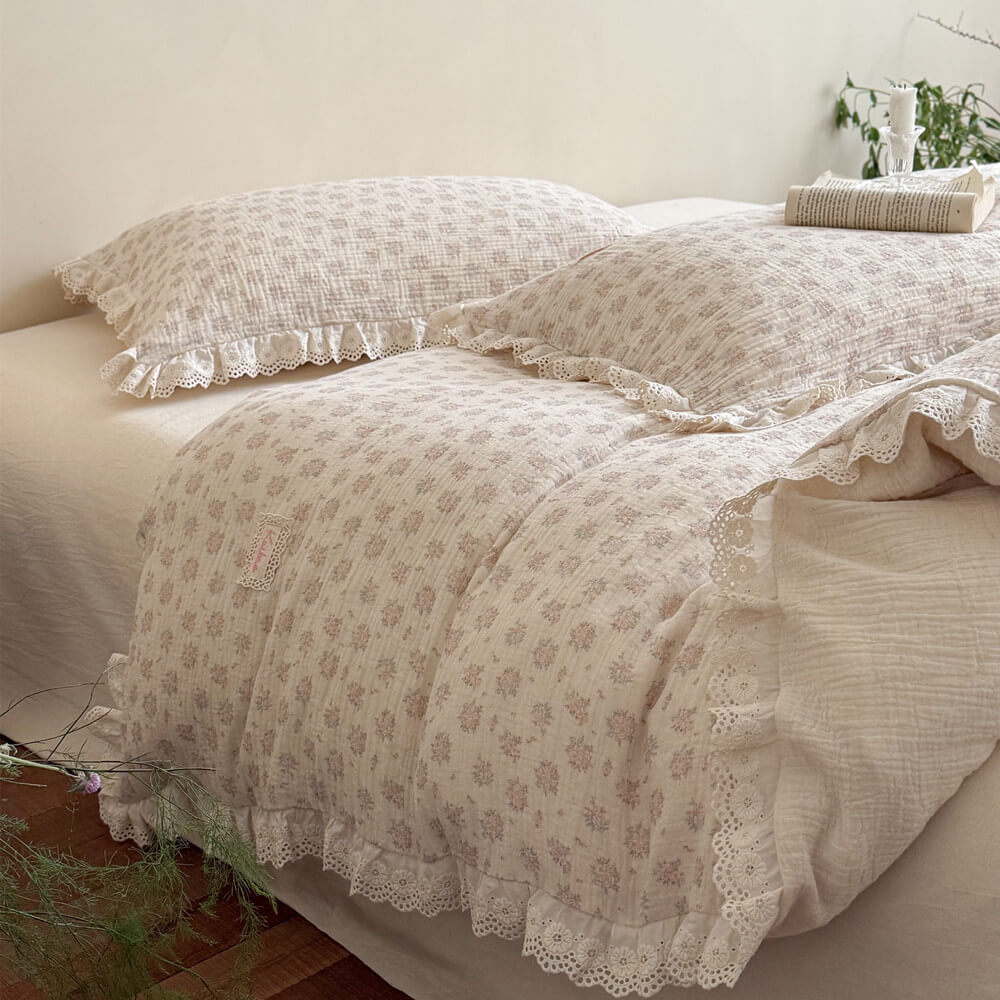 Side view of luxurious French cottage style bedding with crinkled cotton-linen fabric texture, dainty floral prints, and scalloped lace edge ruffles.