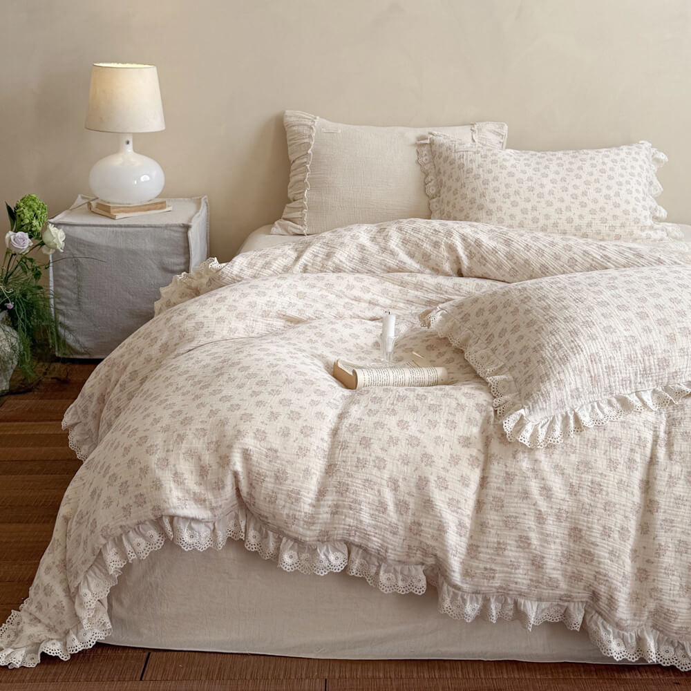 Cozy bedroom setup showcasing a full dusty pink vintage rose comforter set with heavy ruffle borders and aesthetic neutral bedroom decor.