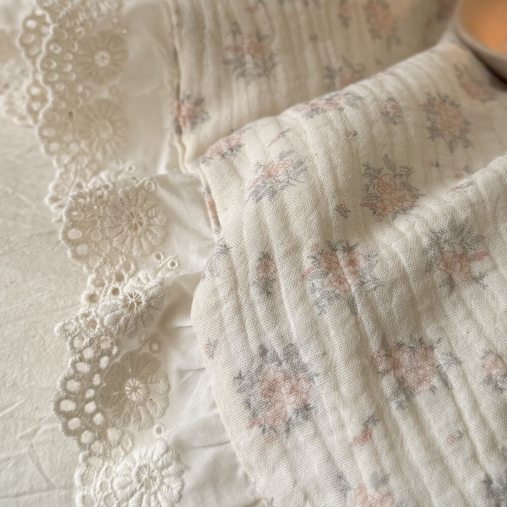 Ultra close-up of the premium 90% cotton 10% linen blend fabric, showing the intricate embroidered lace ruffle edge and delicate floral weave.