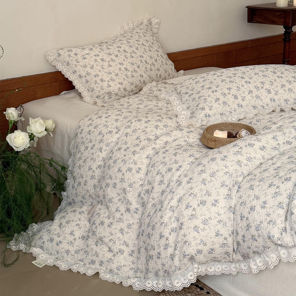 Soft blue rose floral bedding set with lace ruffle details in an ivory cottage bedroom