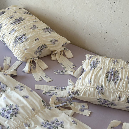 Overhead detail of lavender floral bedding set showing ruched cotton muslin fabric, ribbon ties, and soft cottage floral design.