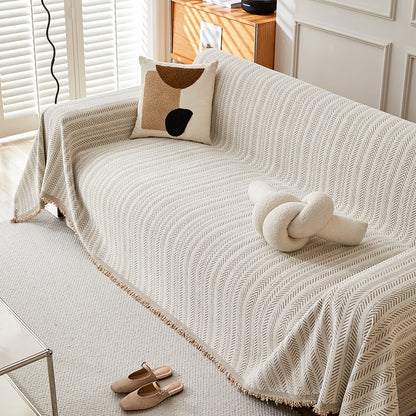 Modern herringbone one-piece sofa cover in neutral living room with abstract pillow and knot cushion