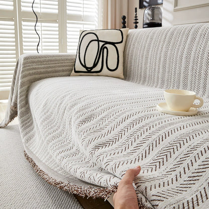 Modern herringbone one-piece sofa cover in a bright living room with abstract pillow and teacup