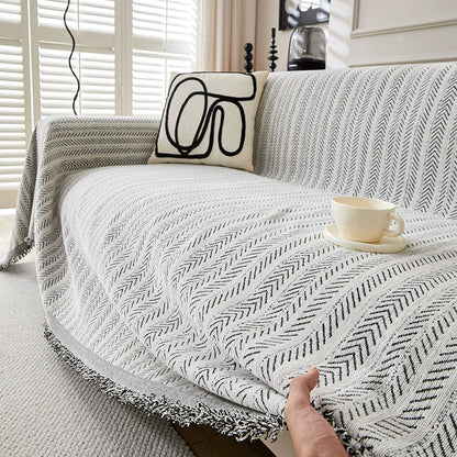 Modern herringbone one-piece cotton sofa cover in bright living room with cup and pillow