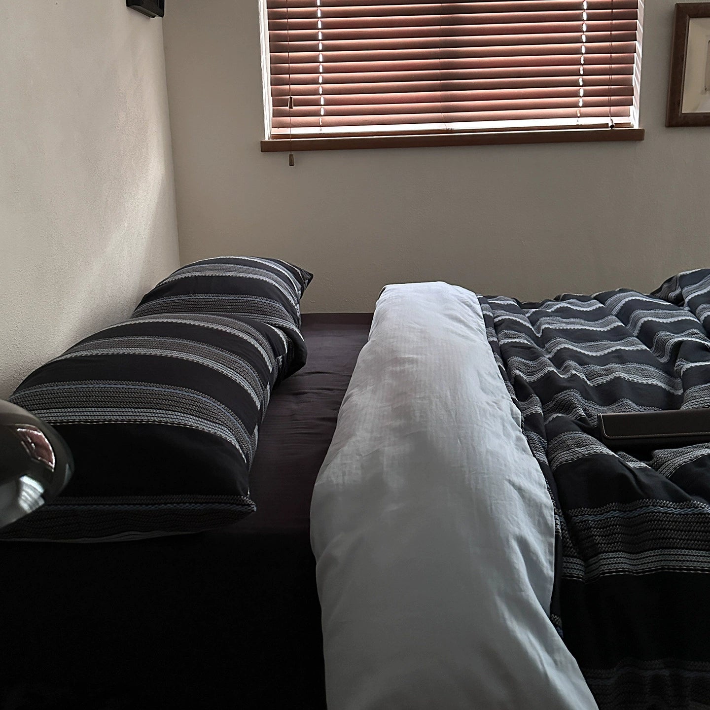 Modern bedroom setup with deep blue striped cotton bedding set and horizontal window blinds