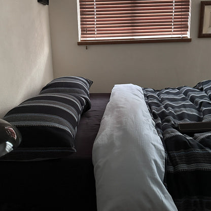 Modern bedroom setup with deep blue striped cotton bedding set and horizontal window blinds