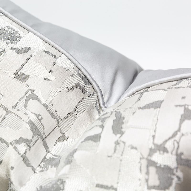 Modern metallic decorative pillow cover in silver and white, close-up texture detail