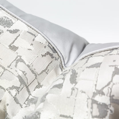 Modern metallic decorative pillow cover in silver and white, close-up texture detail