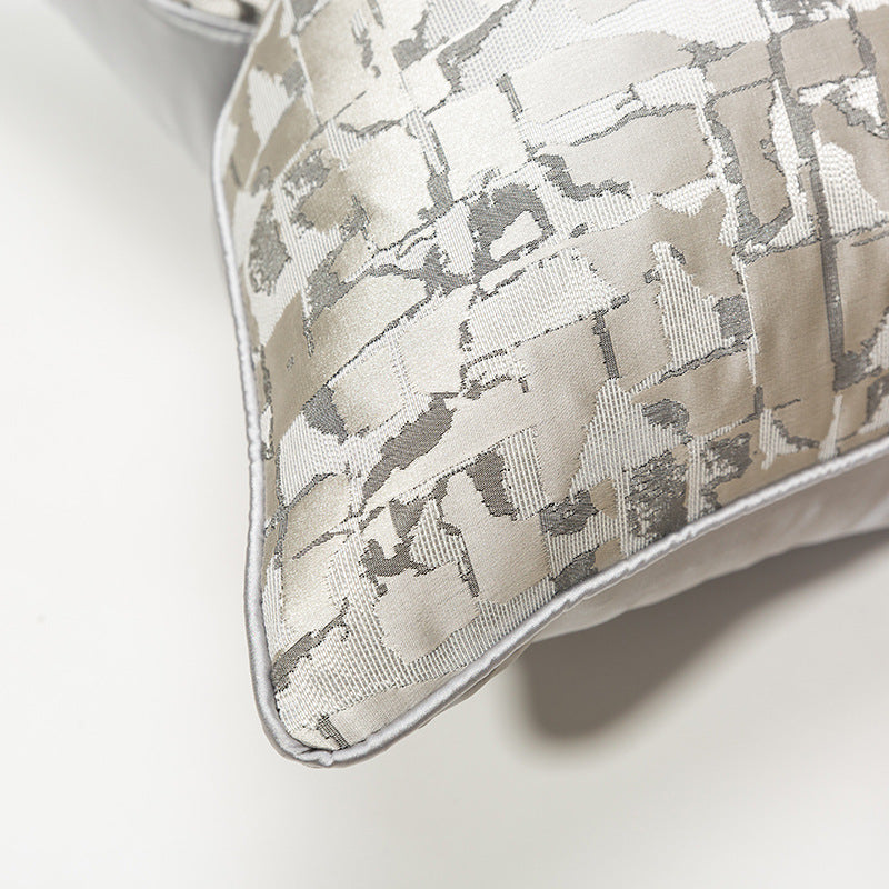 Modern metallic decorative pillow cover with abstract silver pattern on light fabric