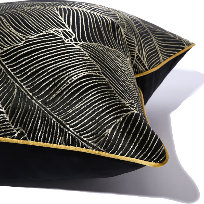 Modern black cushion cover with gold minimalist leaf pattern and yellow trim from StuffedHome