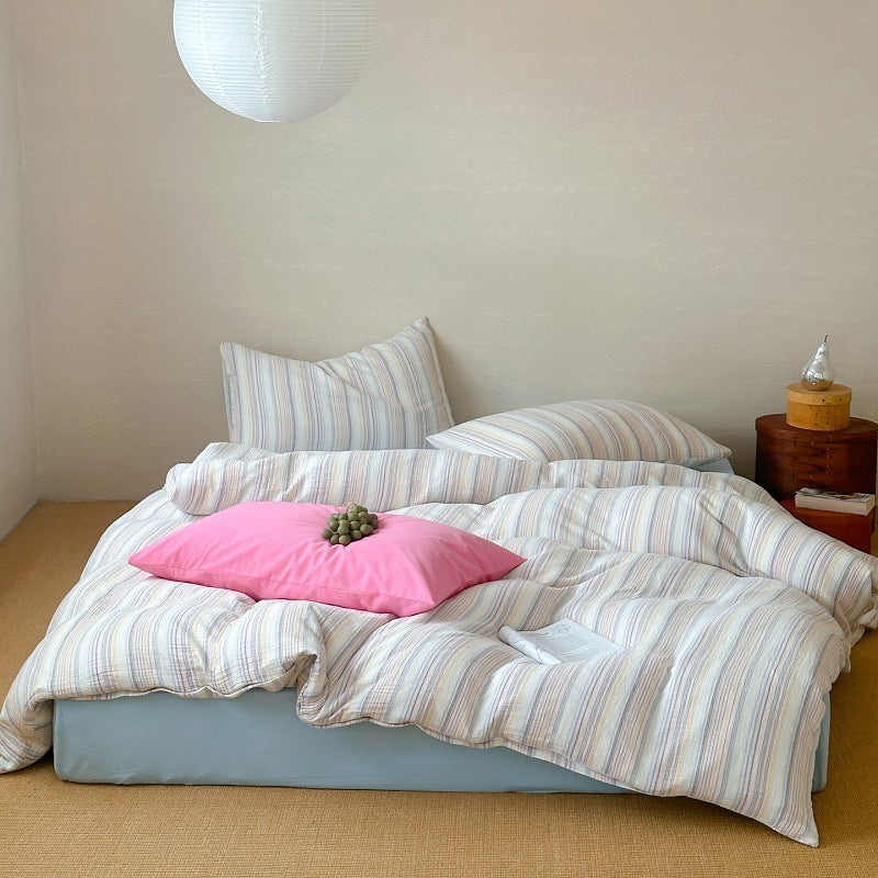 Modern striped duvet cover set with pastel colors, pink accent pillow, cozy bedroom setting
