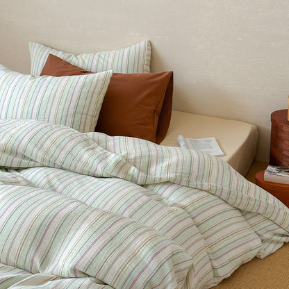 Modern striped duvet cover set with matching pillows on a neatly made bed in a cozy bedroom.