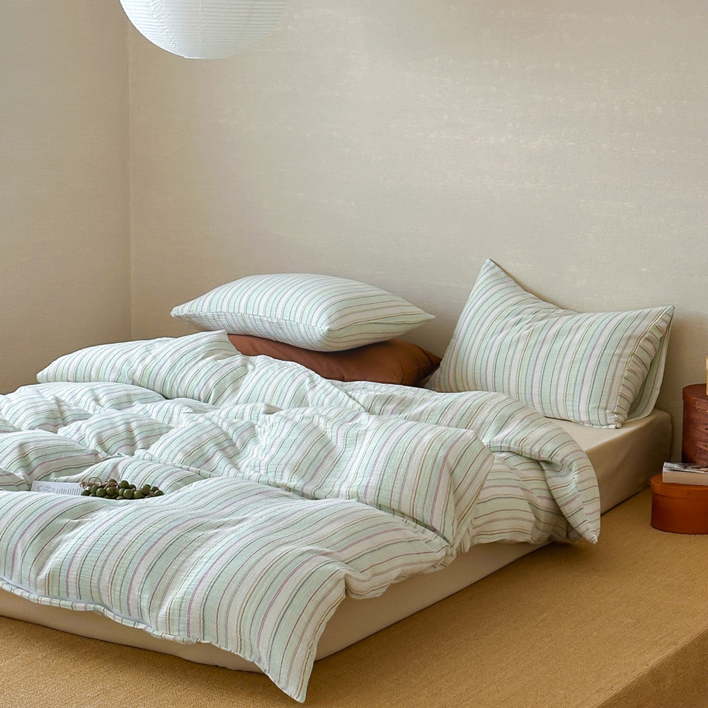 Modern striped duvet cover set with pillows on a cozy bed in a minimalist bedroom