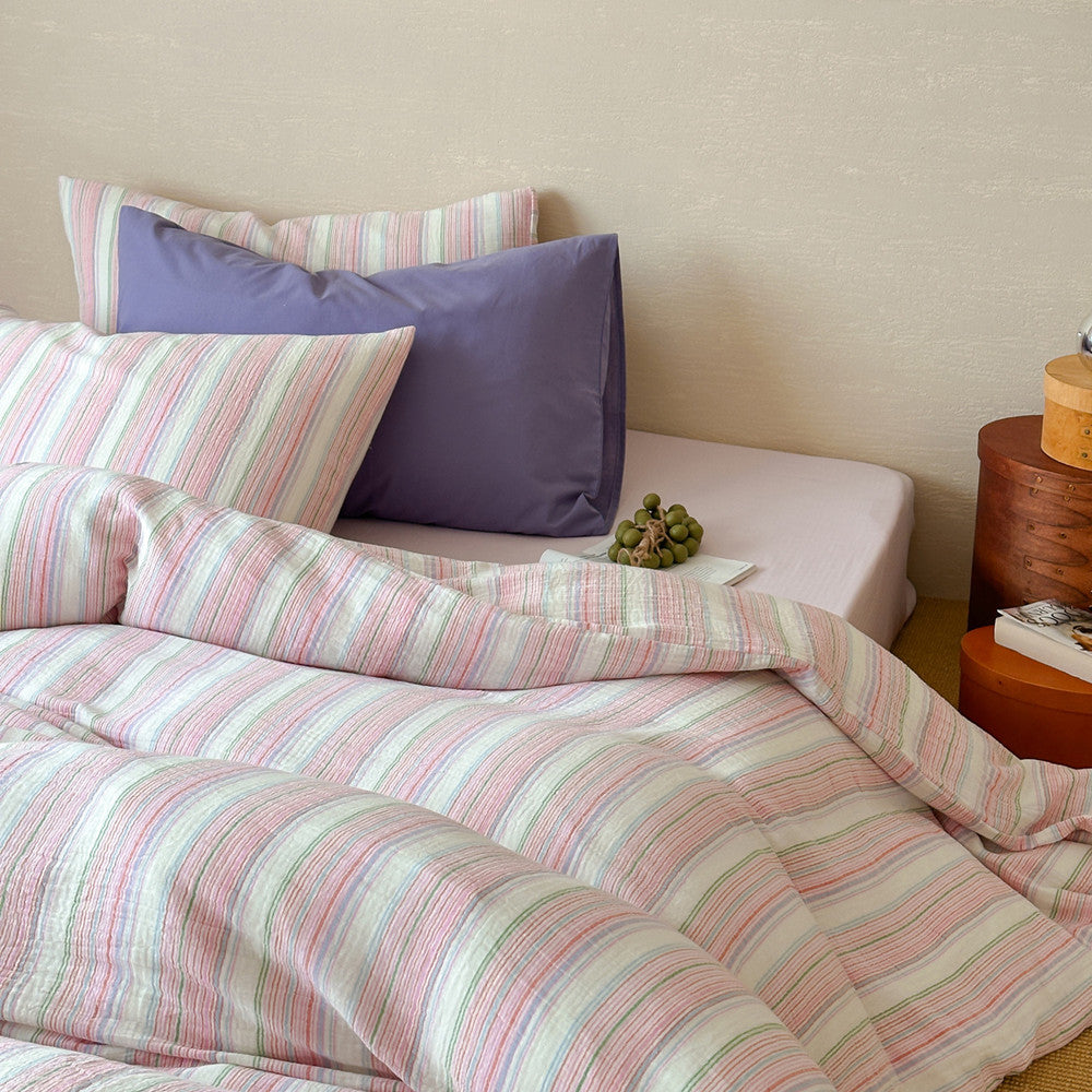 Modern striped cotton duvet cover set with pastel colors and purple pillow in cozy bedroom