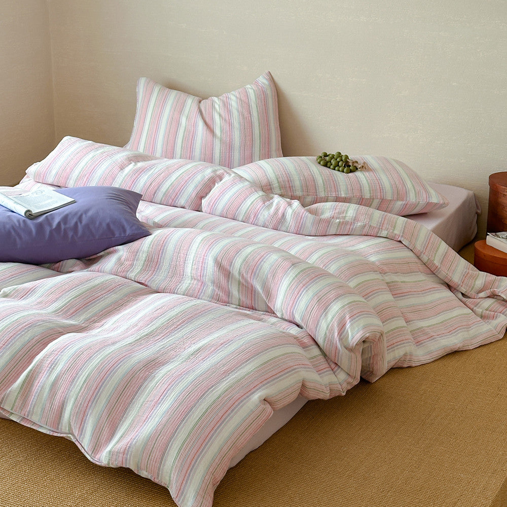Modern striped duvet cover set with pastel pink and green cotton bedding in cozy bedroom
