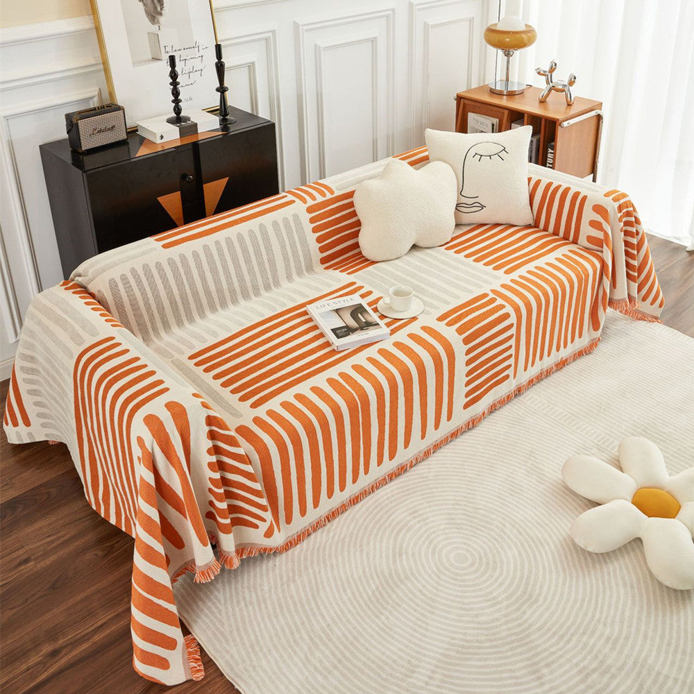 Modern sofa with orange and beige geometric reversible cover, cream pillows, StuffedHome decor