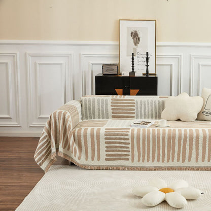 Modern living room with geometric sofa cover, cozy throws, flower pillow, and framed art by StuffedHome