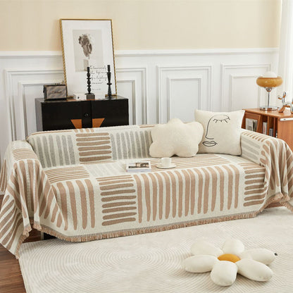 Reversible geometric sofa cover in beige and taupe on modern couch with accent pillows, StuffedHome