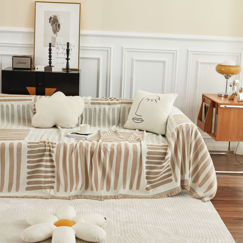 Beige geometric sofa cover in a modern living room with decorative pillows and minimalist decor