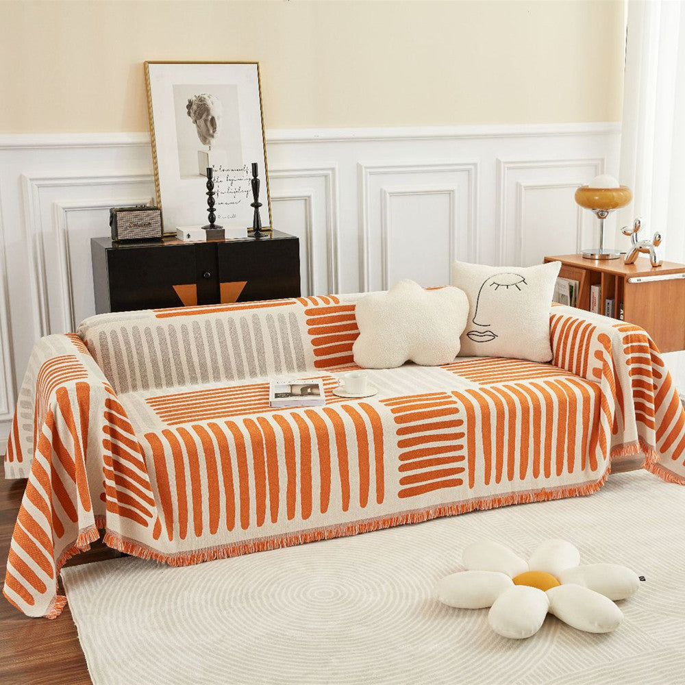 Modern living room with orange geometric reversible cotton sofa cover and decorative pillows from StuffedHome
