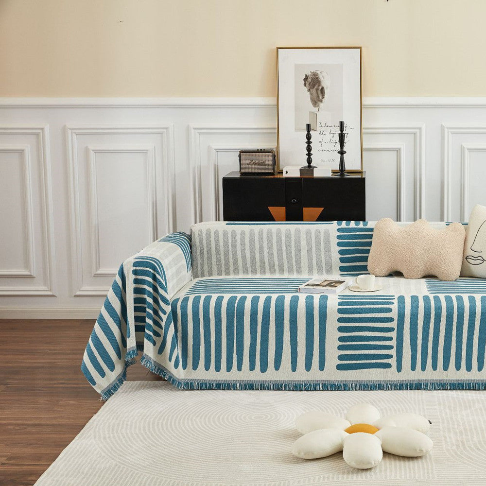 Modern living room with blue reversible geometric sofa cover, cotton decor, and plush flower pillow