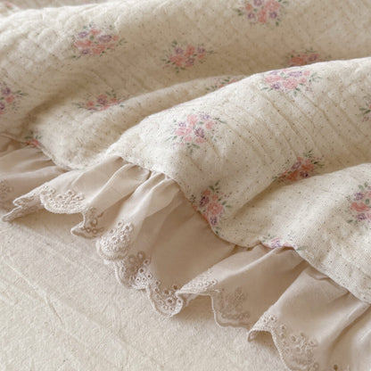 Macro detail of pink floral muslin fabric with ivory embroidered ruffled lace trim