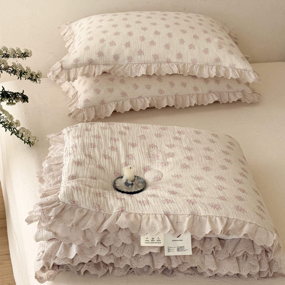 Overhead view of pink floral cotton comforter with matching pillows and cottage lace trim