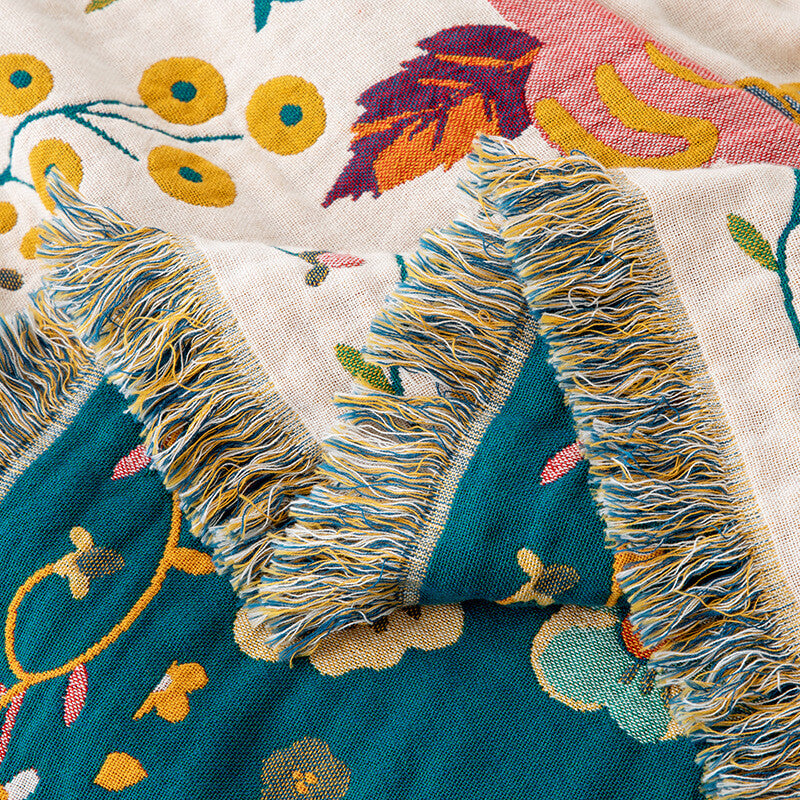 Close-up of fringe edge on reversible floral cotton throw blanket with deep teal reverse side