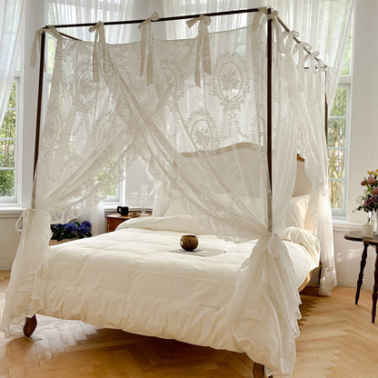 Romantic lace bed canopy curtain with ties over a luxury cotton bed in a bright bedroom