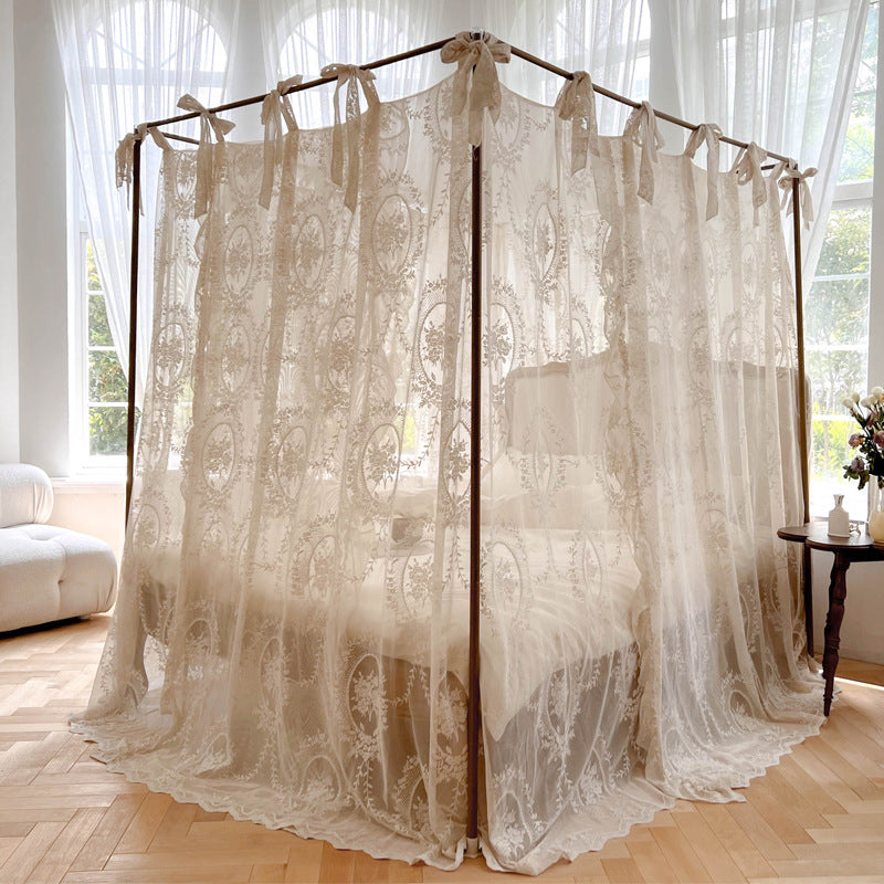 Elegant lace bed canopy curtain with bows in a sunlit, cozy bedroom with white bedding