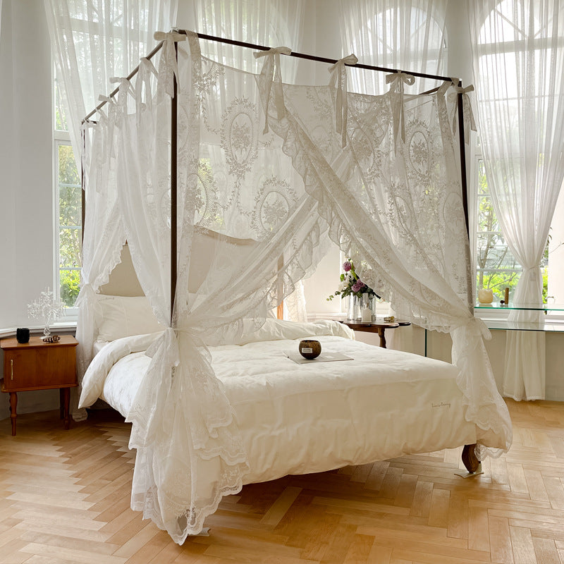 Romantic lace canopy bed with white cotton bedding in a bright, elegant bedroom