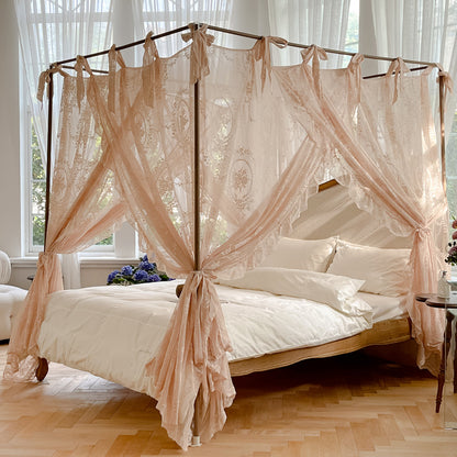 Romantic lace bed canopy curtain with ties over a luxurious natural cotton bed in sunlit bedroom.