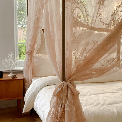 Romantic lace bed canopy curtain with ties over white cotton bedding in a cozy bedroom
